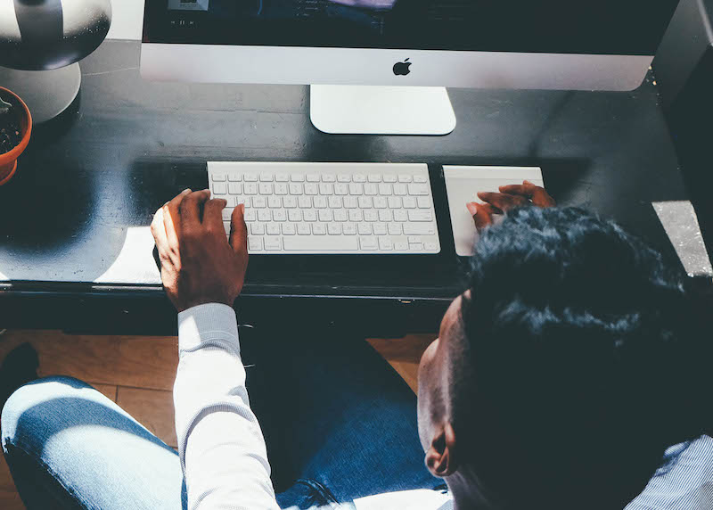 Man sitting working on an apple computer