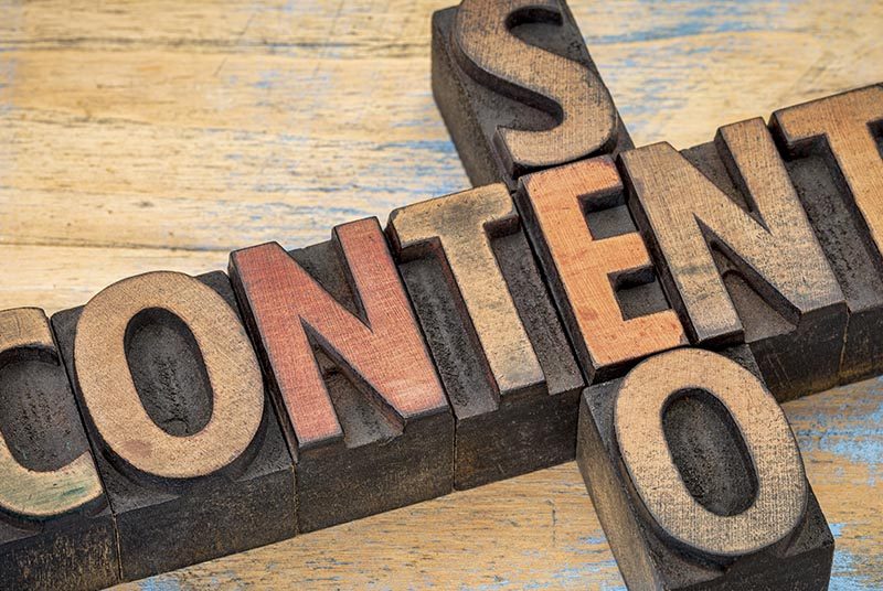 The word content is intersected at the 'E" with SEO travelling horizontally down.|Two men looking at a whiteboard with SEO strategy written in pen|A hand holds a post-it note with SEO written on it and the words keywording