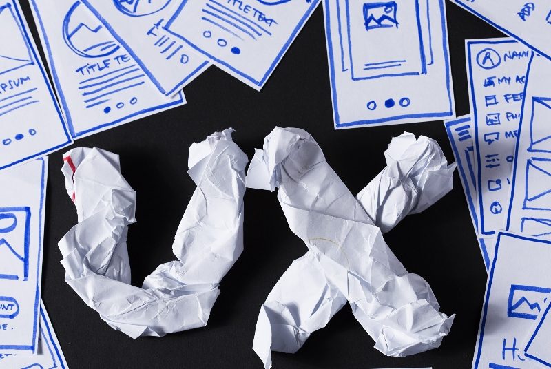 UX Design in screwed up paper with designs littered around