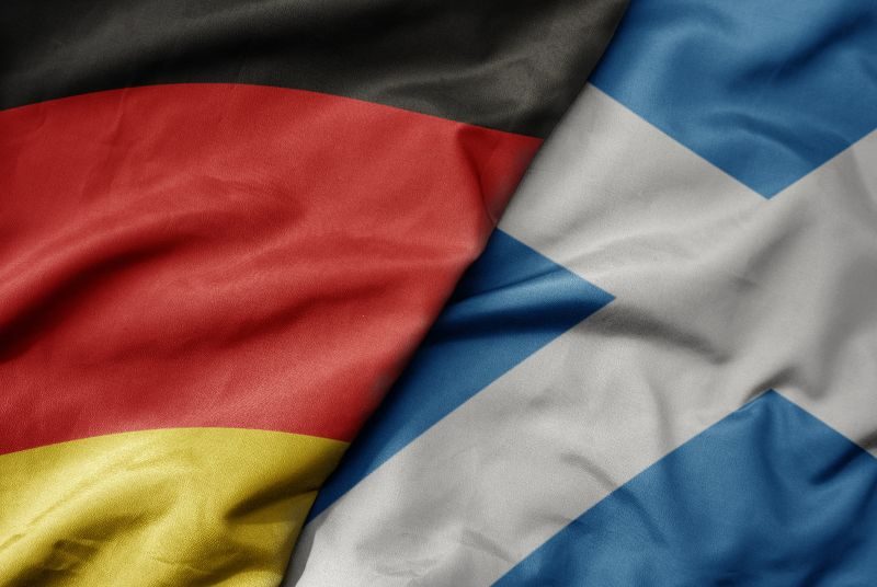 big waving realistic national colorful flag of germany and national flag of scotland.